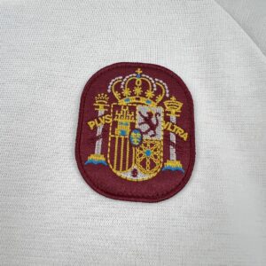 Camiseta España 2026 Visita Niño - detalle franjas de hombro