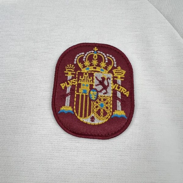 Camiseta España 2026 Visita Niño - detalle franjas de hombro